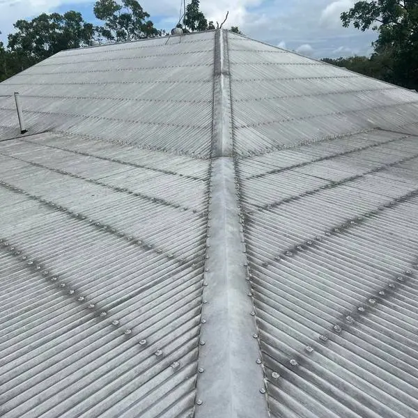 A long roof valley from above, the sheeting washed clean on both sides of the ridge