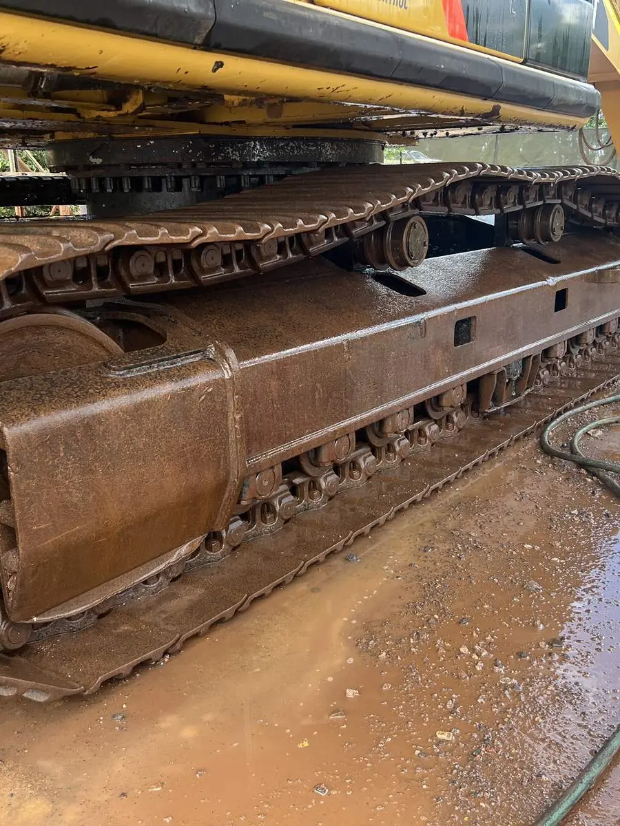 A Power Clean NT operator washing down the tracks and undercarriage of an excavator on a wet washdown pad in Darwin