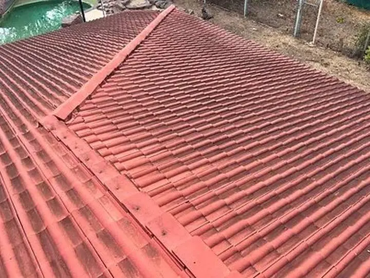 A Territory roof part way through a soft wash, the clean sheeting showing through the mould