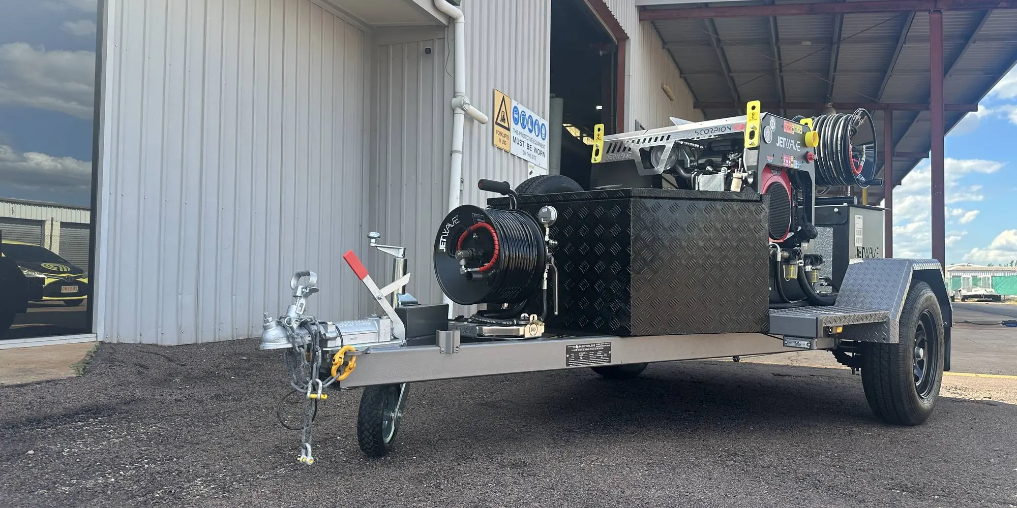 A trailer mounted Jetwave high pressure unit with hose reels, parked at the Darwin depot shed