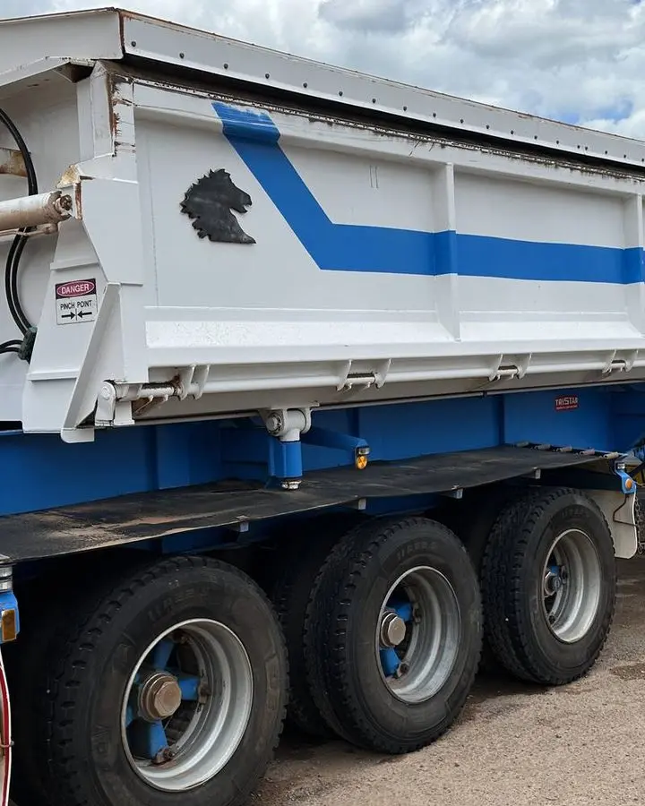 Two washed road train tipper trailers parked on red dirt at the Power Clean NT yard